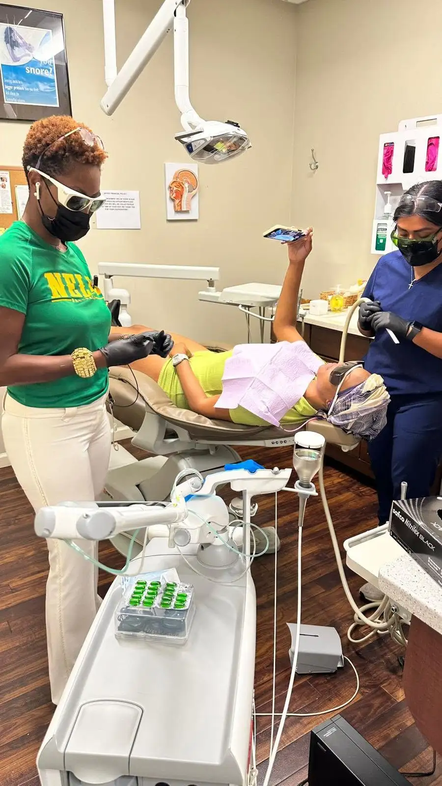 Dr. Nelly Silva wearing loupes examines a patient's teeth in the dental chair at our Collegeville office