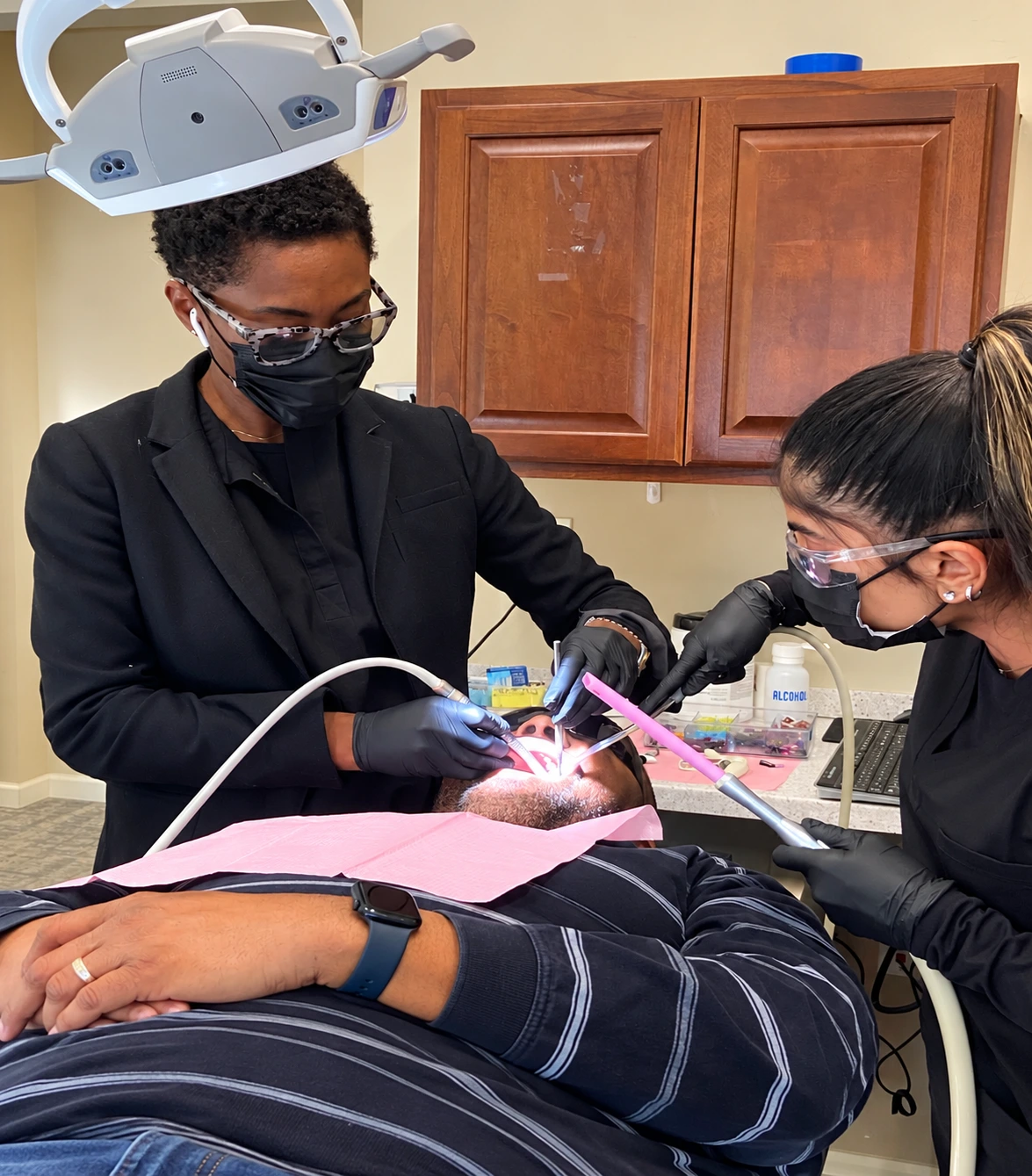Dr. Nelly Silva and dental assistant performing a procedure on a patient