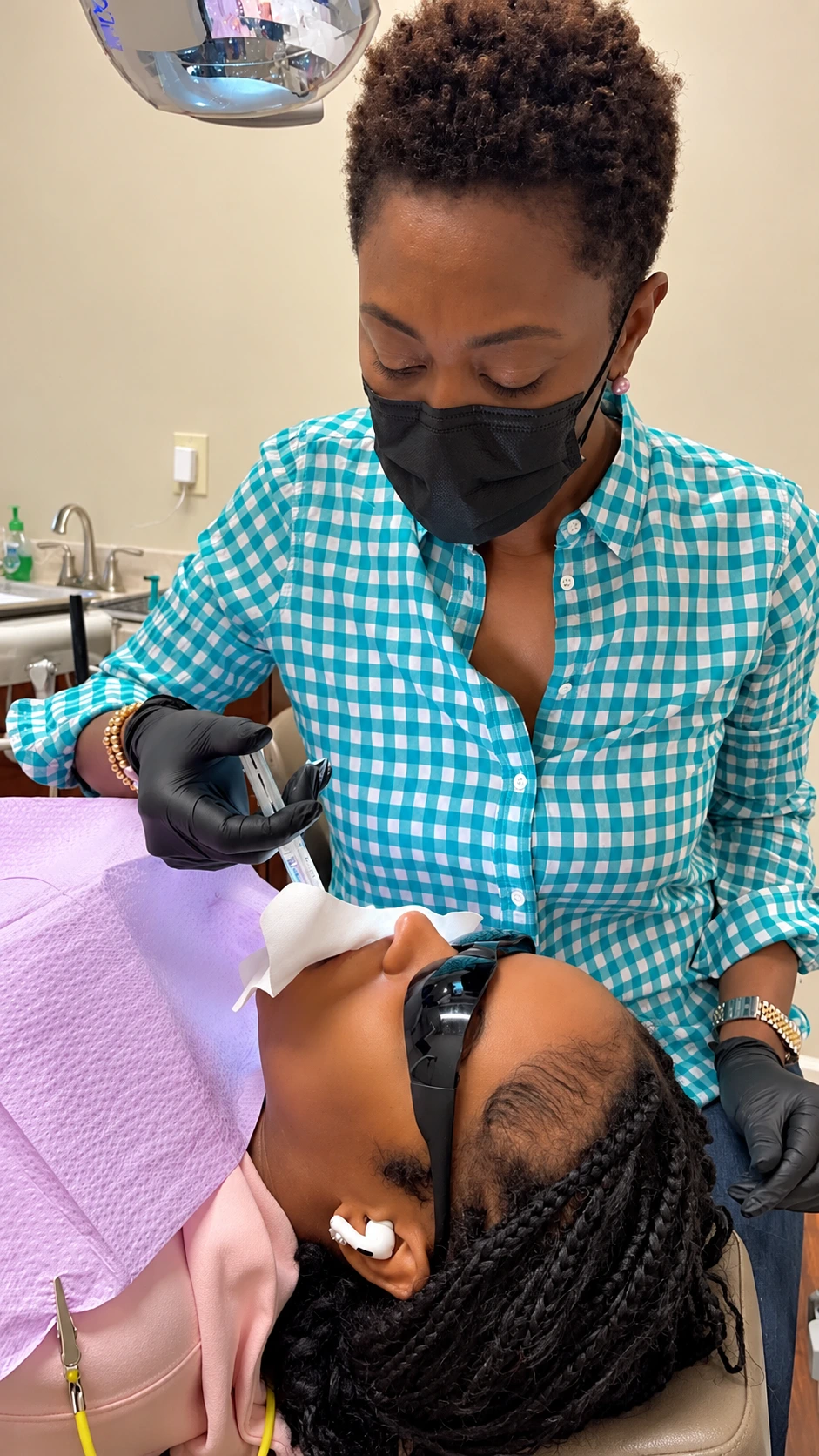 Dental professional applying cosmetic treatment to a patient in the chair during a KoR whitening visit
